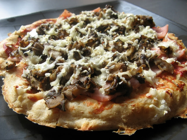 Wyrośnięta pizza pełnoziarnista z camembertem, szynką i pieczarkami